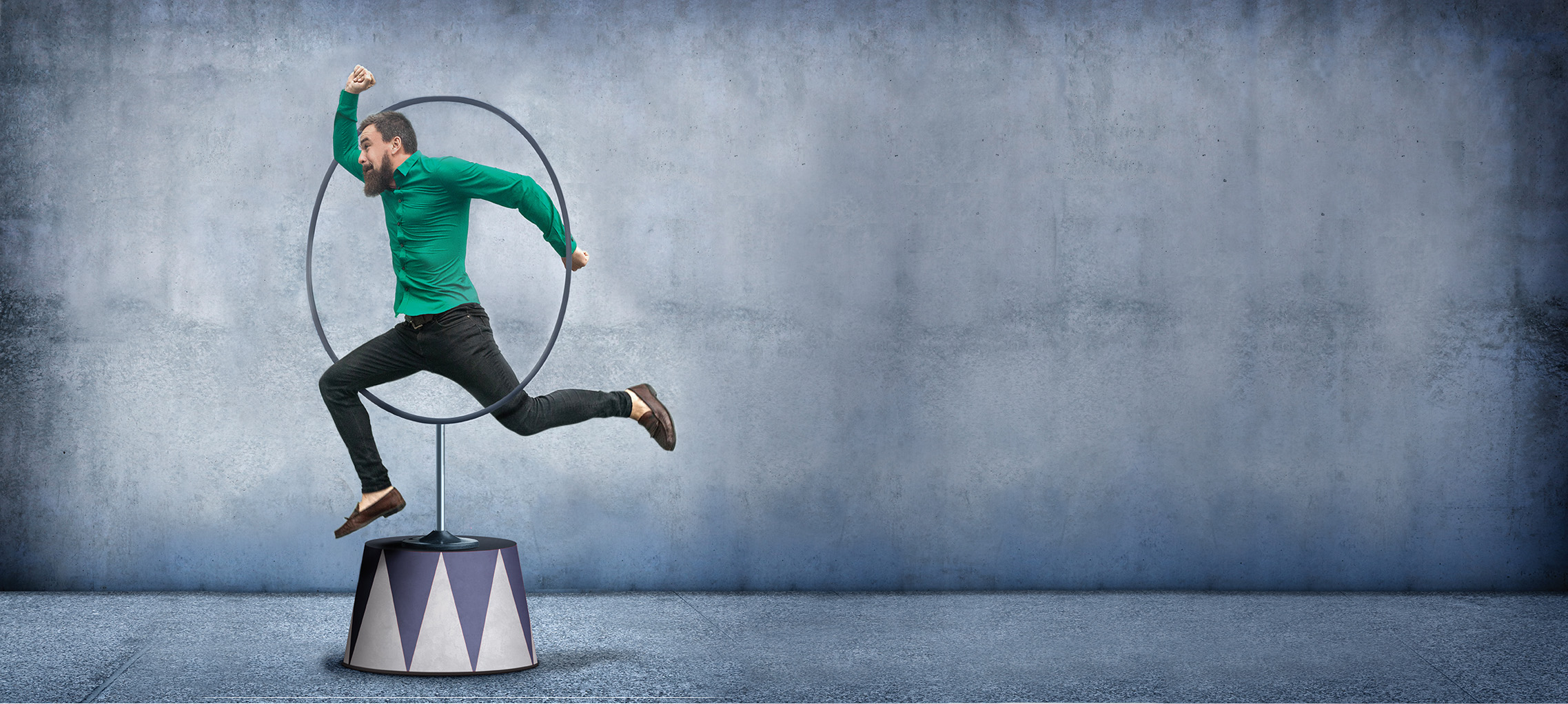 A businessman jumps through a hoop - the concept of a businessman doing whatever is necessary to get the job done.