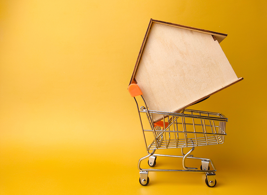 Decorative image of wooden house in shopping cart.
